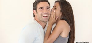 Beautiful woman whispering to boyfriend's ear