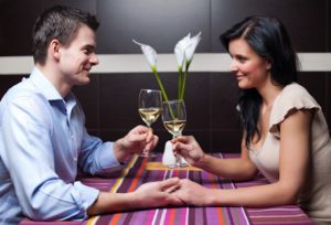 Young couple drinking wine and flirting